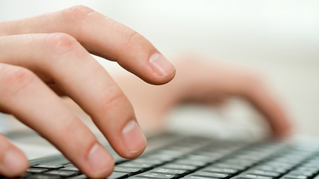 Des mains tapent sur un clavier d’ordinateur